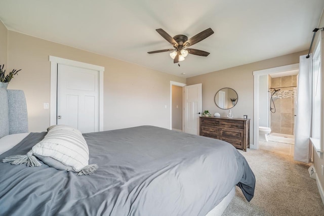 bedroom with light carpet, a ceiling fan, and ensuite bath