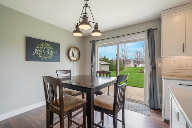 dining room featuring baseboards and dark wood-style floors