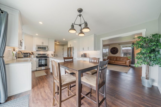 dining room with dark wood-type flooring and recessed lighting