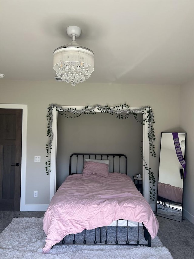 bedroom featuring carpet floors, baseboards, and a notable chandelier