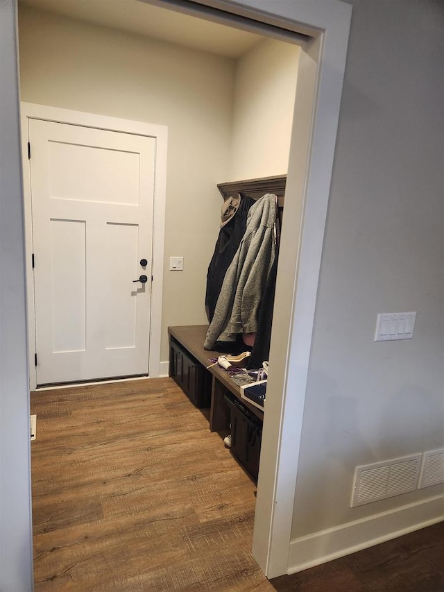 mudroom with baseboards, visible vents, and wood finished floors