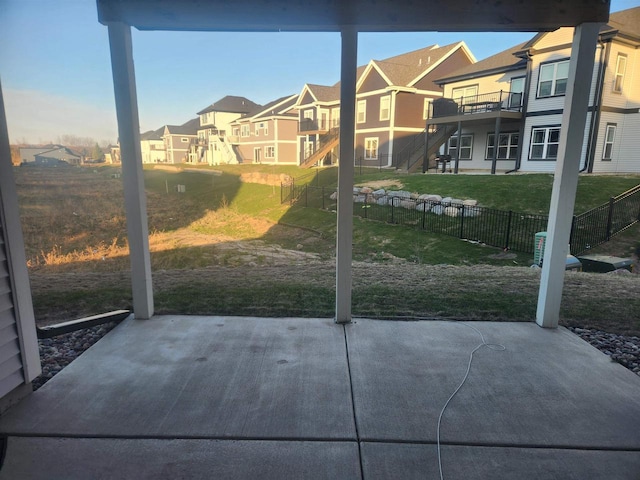 view of patio featuring a deck, a residential view, a fenced backyard, and stairs