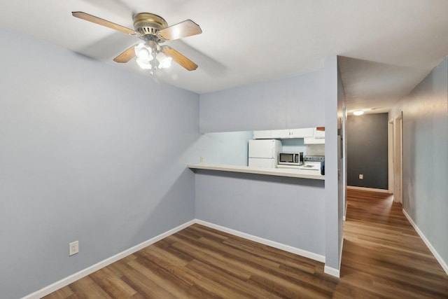 empty room with baseboards, ceiling fan, and dark wood finished floors