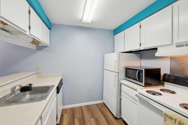 kitchen featuring a sink, white appliances, light countertops, wood finished floors, and under cabinet range hood