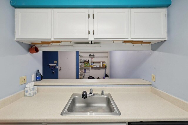 kitchen with a sink, white cabinets, and light countertops