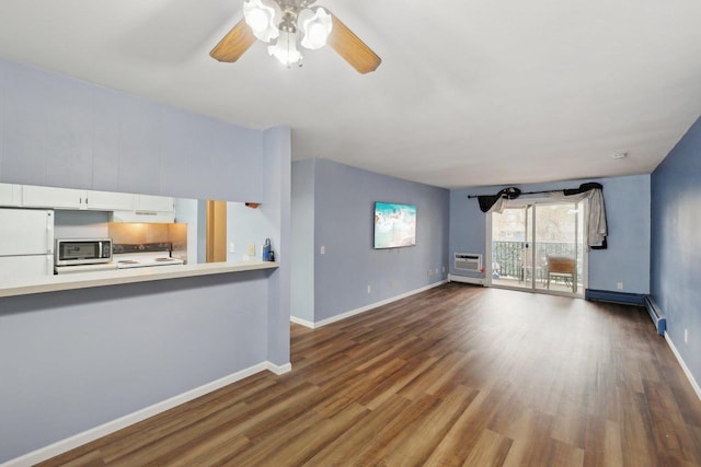 unfurnished living room with baseboards, a ceiling fan, a wall mounted air conditioner, and dark wood-style floors