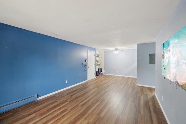 unfurnished room with a ceiling fan, baseboards, baseboard heating, and wood finished floors