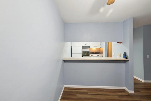 kitchen featuring range with electric cooktop, freestanding refrigerator, white cabinetry, baseboards, and dark wood-type flooring