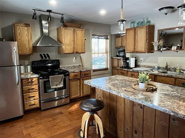 12014 102nd, Chippewa Falls, WI 54729 - kitchen with dark wood finished floors, appliances with stainless steel finishes, brown cabinets, and wall chimney range hood
