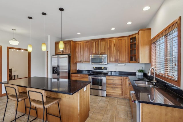 kitchen featuring a center island, brown cabinets, a sink, stainless steel appliances, and recessed lighting