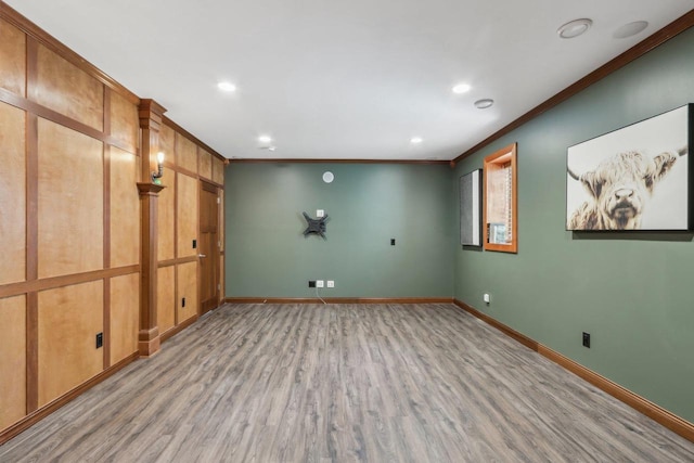 below grade area featuring light wood-style floors, recessed lighting, baseboards, and crown molding