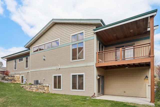 rear view of property featuring central AC, a yard, and a balcony