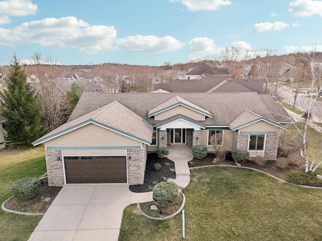 ranch-style home featuring an attached garage, a front lawn, driveway, and stone siding