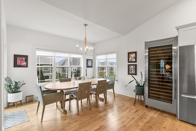 dining room with a wealth of natural light, light wood-style flooring, beverage cooler, and a chandelier