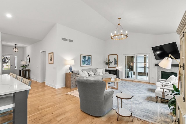 living area with a notable chandelier, visible vents, plenty of natural light, and light wood finished floors