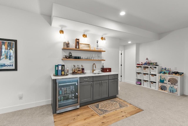 bar featuring light colored carpet, a sink, baseboards, indoor wet bar, and wine cooler