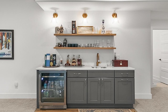 bar with wine cooler, light carpet, baseboards, a sink, and wet bar