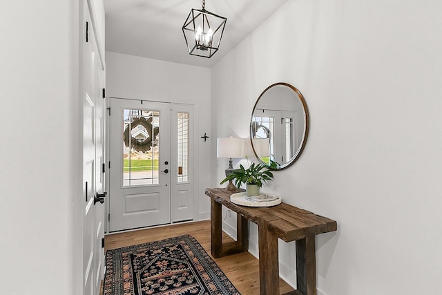 entrance foyer with an inviting chandelier, baseboards, and light wood-style flooring