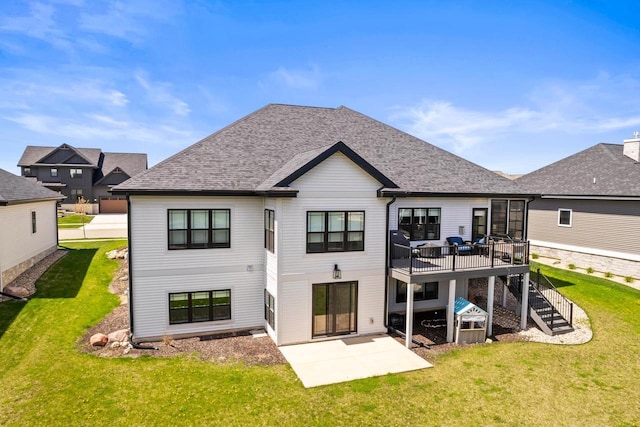 back of house featuring roof with shingles, stairs, a deck, a lawn, and a patio