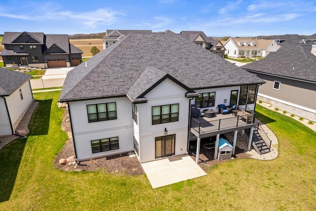 back of property with a shingled roof, a yard, a residential view, and a deck
