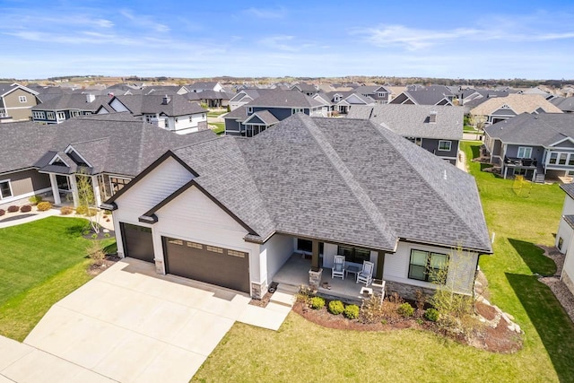 view of front of home with a garage, a shingled roof, a porch, and a residential view