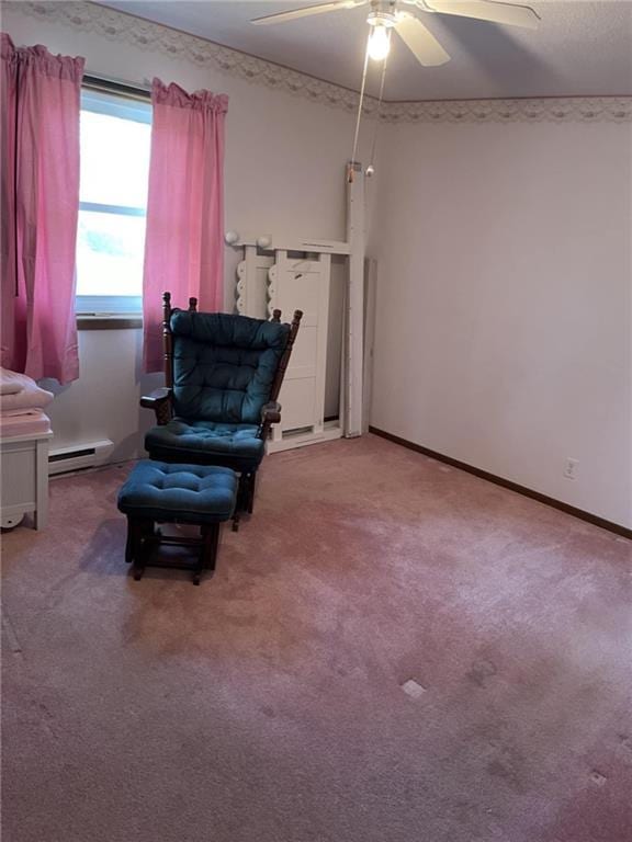living area with light colored carpet, ceiling fan, and a baseboard heating unit