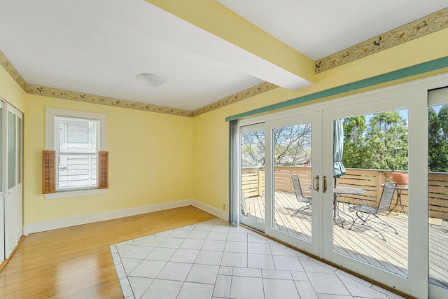interior space with french doors, light wood-style flooring, baseboards, and beamed ceiling