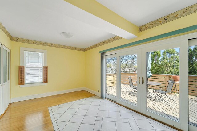 interior space with french doors, light wood-style flooring, baseboards, and beamed ceiling