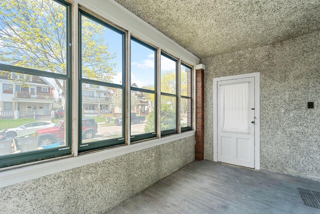 unfurnished sunroom featuring wood finished floors