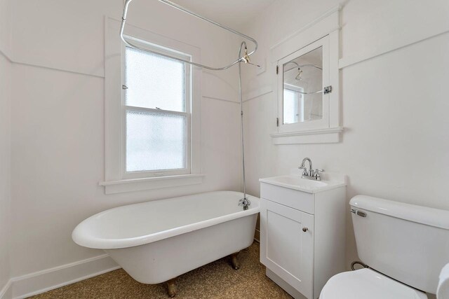 bathroom featuring a freestanding tub, walk in shower, baseboards, vanity, and toilet