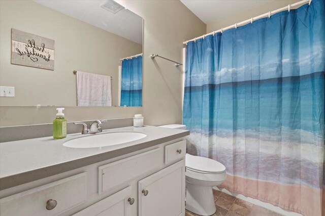 bathroom with vanity, a shower with shower curtain, visible vents, and toilet