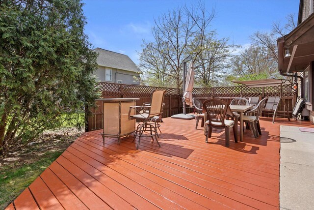 deck featuring a fenced backyard and outdoor dining space