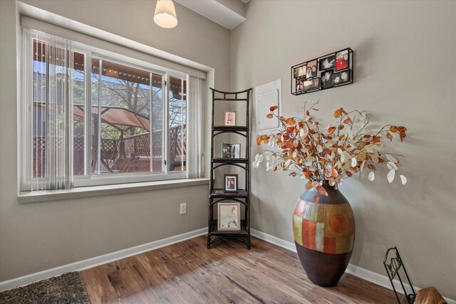 living area with baseboards and wood finished floors