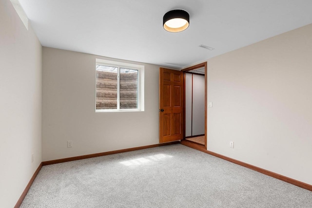 carpeted spare room featuring baseboards and visible vents