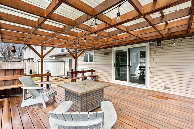 wooden deck featuring fence, a storage unit, a pergola, and an outdoor structure
