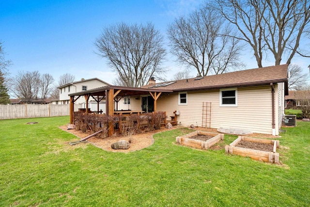rear view of house with a lawn, fence, a vegetable garden, and a chimney