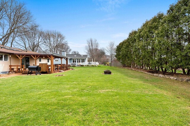 view of yard featuring fence and a fire pit