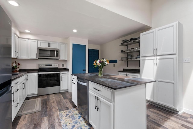 kitchen featuring dark countertops, appliances with stainless steel finishes, open shelves, and dark wood-style flooring