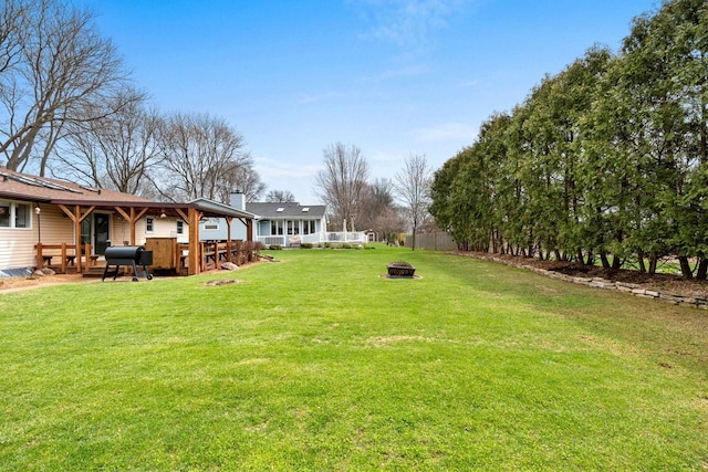 view of yard featuring fence and a fire pit