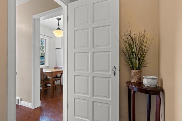 doorway to outside featuring baseboards and dark wood-style floors