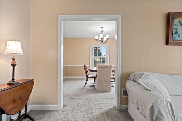 bedroom with baseboards, a notable chandelier, and carpet
