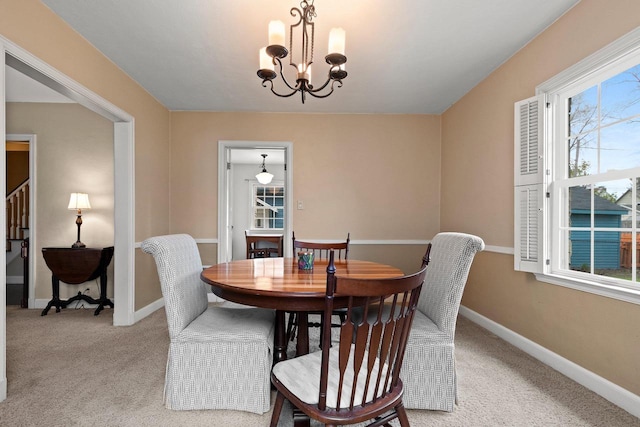 dining space featuring plenty of natural light, carpet flooring, and a chandelier