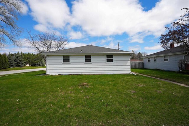 back of house with a lawn and fence