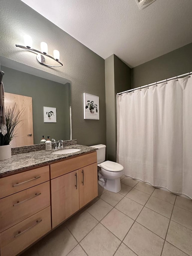 full bathroom with toilet, a textured ceiling, tile patterned floors, and vanity