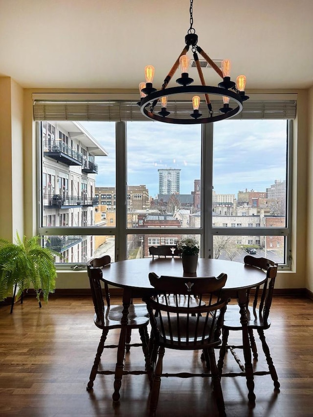 dining space featuring a city view, wood finished floors, and a notable chandelier