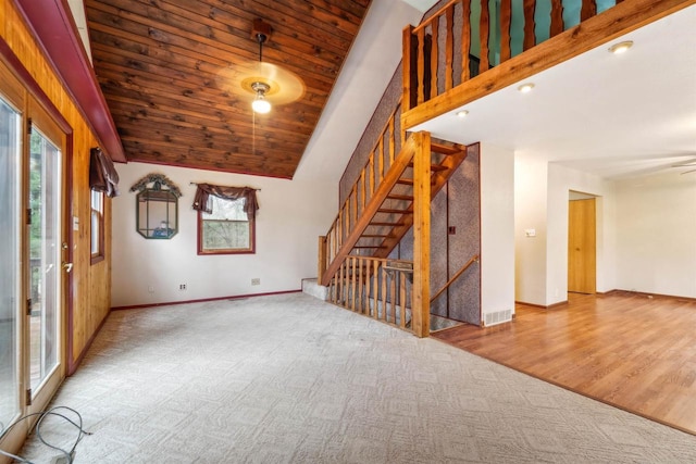 W7126 N Oakwood Cir, Neshkoro, WI 54960 - unfurnished living room with baseboards, stairs, carpet flooring, and vaulted ceiling