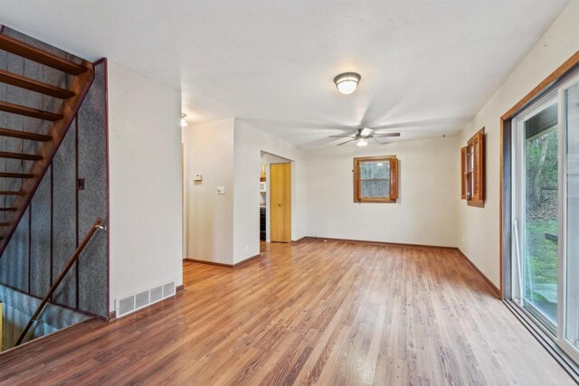 W7126 N Oakwood Cir, Neshkoro, WI 54960 - spare room featuring baseboards, ceiling fan, visible vents, wood finished floors, and stairway