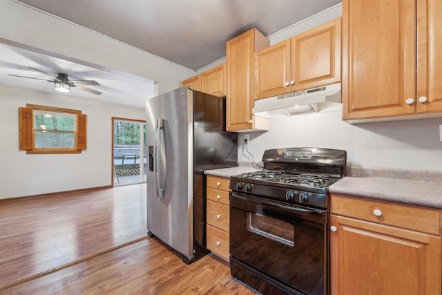 W7126 N Oakwood Cir, Neshkoro, WI 54960 - kitchen featuring black gas stove, under cabinet range hood, light wood finished floors, stainless steel fridge, and light countertops