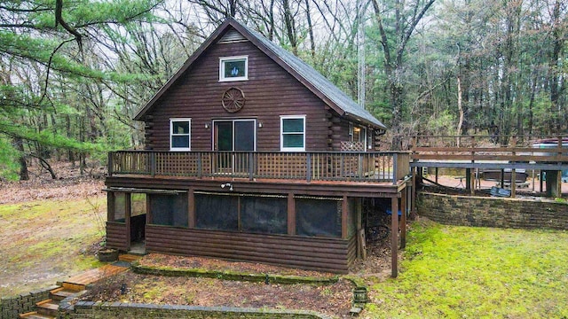 W7126 N Oakwood Cir, Neshkoro, WI 54960 - back of property with log siding, a deck, a forest view, and a lawn