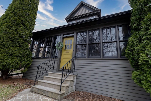view of front facade featuring a sunroom and entry steps